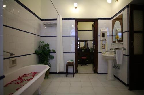 a bathroom with a bath tub and a sink at Gajner Palace-Heritage by HRH Group of Hotels in Gajner