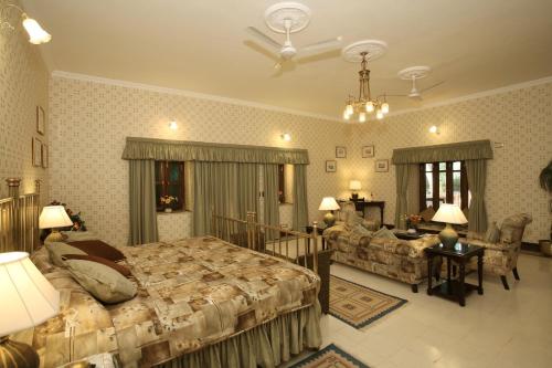 a large bedroom with a bed and a table and chairs at Gajner Palace-Heritage by HRH Group of Hotels in Gajner