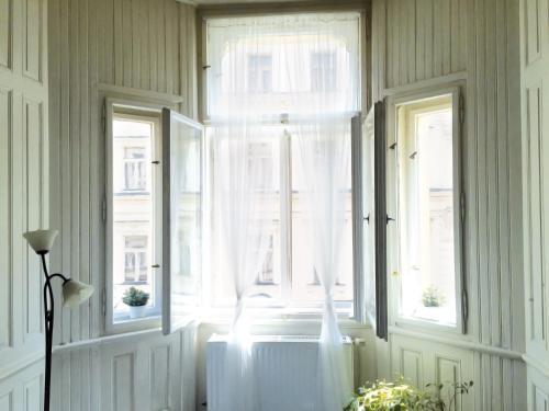 Cette chambre dispose de deux fenêtres avec des rideaux blancs et un radiateur. dans l'établissement VIP city CENTER apartment Prague, à Prague