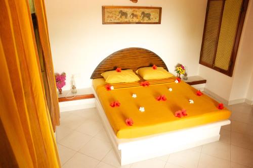 a bedroom with a yellow bed with flowers on it at Eva Lanka Hotel - Beach & Wellness in Tangalle