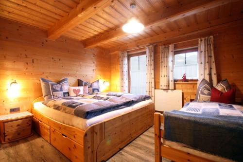 a bedroom with two beds in a log cabin at Almliesl BRAM-618 in Bramberg am Wildkogel