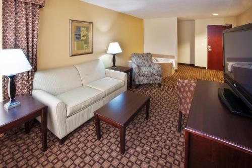 a living room with a couch and a tv at Holiday Inn Quincy by IHG in Quincy