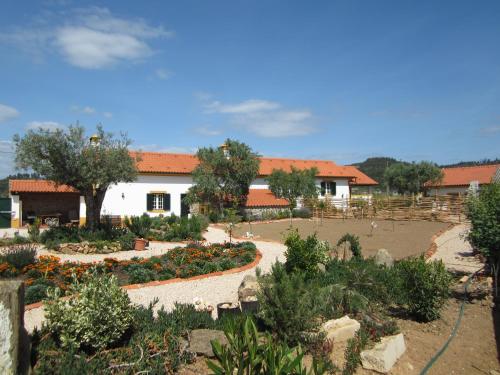 a building with a garden with flowers in front of it at Quinta do Feonix in Martinchel
