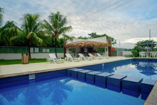 einen Pool mit Stühlen und ein Haus in der Unterkunft Holiday Inn Express Tapachula, an IHG Hotel in Tapachula