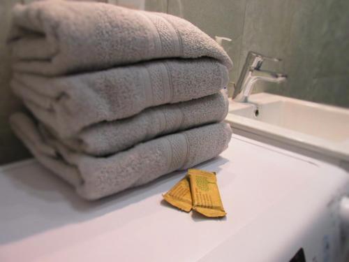 a pile of towels sitting on a counter in a bathroom at Apartament Pucka Przystań in Puck