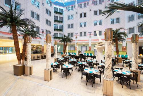a mall with tables and chairs and palm trees at Thon Hotel Oslofjord in Sandvika