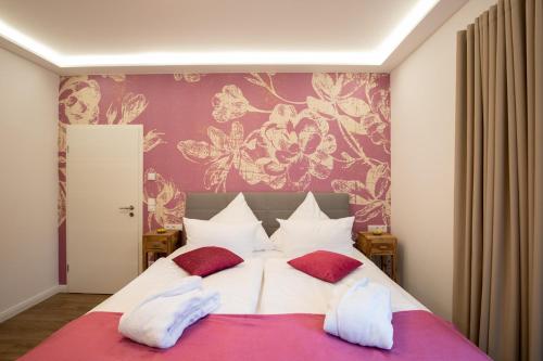 a bedroom with a large bed with red and white pillows at Seeparkvilla in Lychen