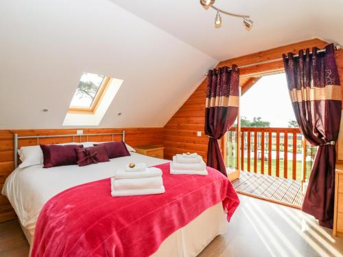 a bedroom with a bed and a balcony at Oak Lodge in Huntly