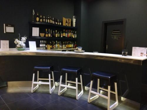 a bar with three stools sitting at a counter at Holiday Inn Milan Nord Zara by IHG in Cinisello Balsamo