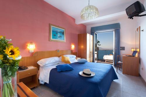 a bedroom with a blue bed with a hat on it at Hotel Settimo Cielo in Sorrento