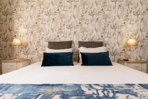 a bedroom with a bed with two blue pillows at Atlantico Apartments in Ribeira Grande
