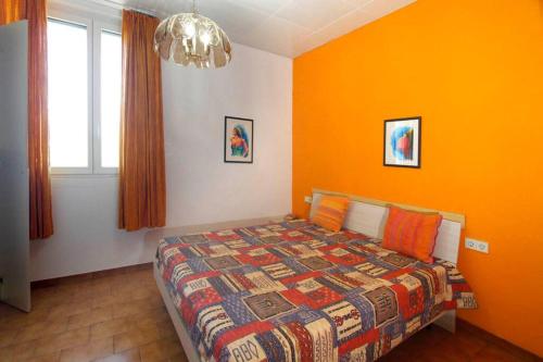 a bedroom with a bed with an orange wall at Euroville 70 in Germignaga