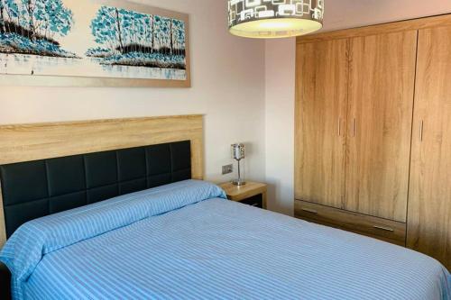 um quarto com uma cama com um cobertor azul em Alojamientos Vandelvira em Jaén