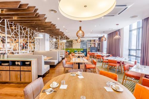 a restaurant with wooden tables and chairs at Holiday Inn Ulaanbaatar by IHG in Ulaanbaatar