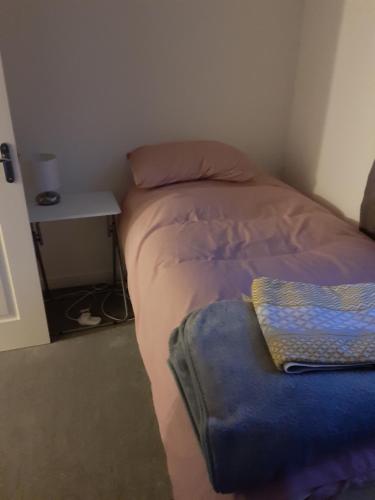 a small bedroom with a bed and a table at Marias House in Newcastle upon Tyne