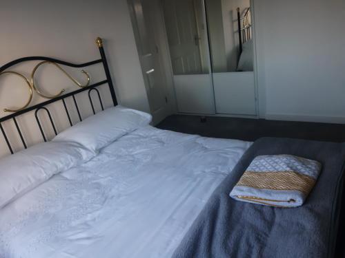 un letto con telaio nero e un asciugamano sopra di Marias House a Newcastle upon Tyne