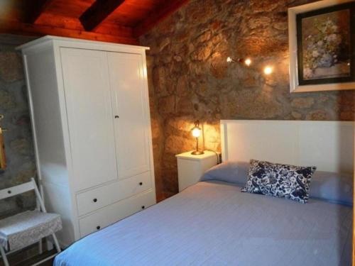 1 dormitorio con cama, armario y almohada en Renllon en Lomo de Arico
