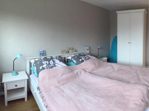 um quarto com uma cama grande e um cobertor rosa em Sophienrast em Husum