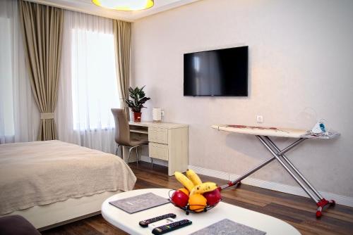 a room with a bed and a table with fruit on it at Abano view apartment in Tbilisi City