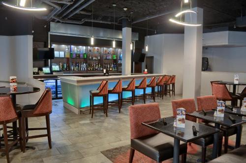 een bar in een restaurant met tafels en stoelen bij Holiday Inn Mobile West I-10, an IHG Hotel in Tillmans Corner