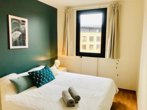 une chambre avec un lit blanc avec une fenêtre dans l'établissement Evry Appartement Cosy // Proche Paris, Évry-Courcouronnes
