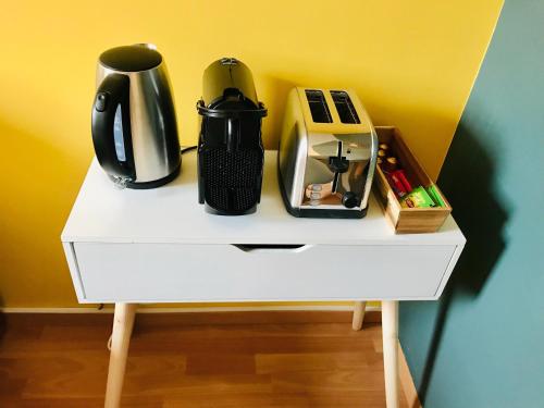 - une table blanche avec une cafetière dans l'établissement Evry Appartement Cosy // Proche Paris, Évry-Courcouronnes