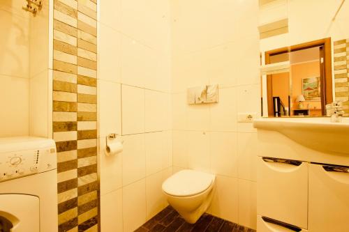 a white bathroom with a toilet and a sink at KvartiraSvobodna - Apartment at Druzhinnikovskaya in Moscow