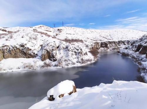 a river with snow on the side of a mountain at Holiday Home Kanyon in Argel