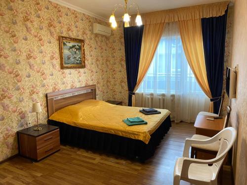 a bedroom with a bed with a yellow bedspread at Hotel Zhemchuzhina in Anapa