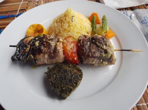 a plate of food with meat and vegetables and rice at Roça Saudade Guest House in Trindade