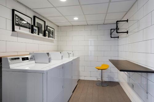 a white kitchen with a counter and a yellow stool at Holiday Inn - Bloomington W MSP Airport Area, an IHG Hotel in Bloomington