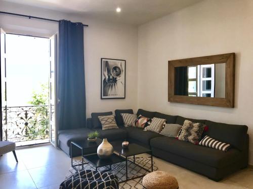un salon avec un canapé et un miroir dans l'établissement Luxueux appt Vieil Antibes Port Plage TOUT équipé pour 8, à Antibes