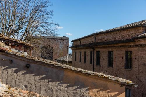 een oud bakstenen gebouw naast een bakstenen muur bij Appartamento Porta Pispini in Siena