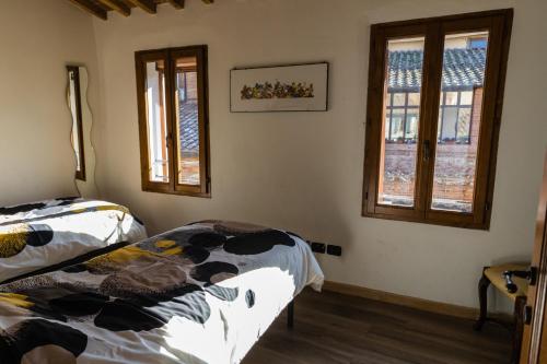 een slaapkamer met twee bedden en twee ramen bij Appartamento Porta Pispini in Siena