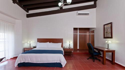 a bedroom with a bed and a desk and a chair at Holiday Inn Veracruz-Centro Historico by IHG in Veracruz