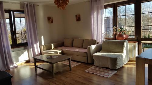 a living room with a couch and chairs and windows at Villa Sole in Pruszcz Gdański