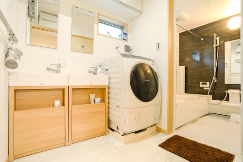 uma casa de banho com uma máquina de lavar roupa num quarto em Zenith's House em Osaka