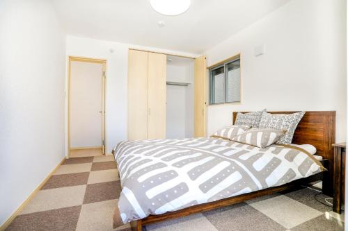 a bedroom with a bed and a window at Zenith's House in Osaka