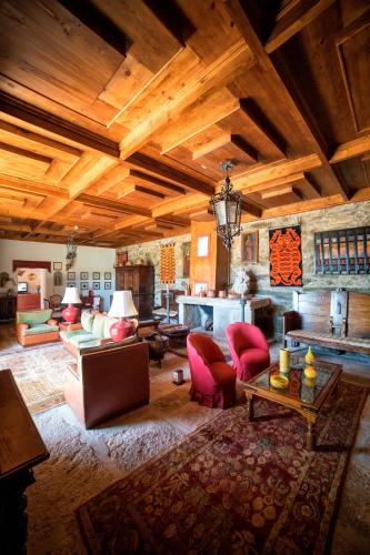 a large living room with wooden ceilings and red chairs at Quinta da Veiga in Covas do Douro