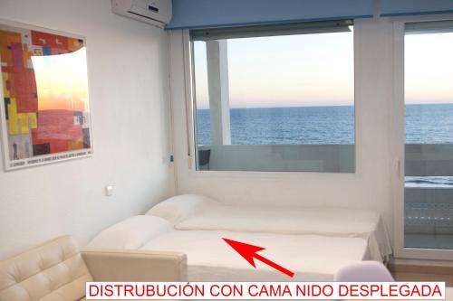 sala de estar con sofá y ventana en Apartamento con vistas al mar primera linea playa Matalascañas, en Matalascañas