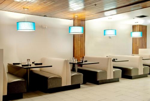 a restaurant with two tables and chairs and blue lights at Holiday Inn Victorville by IHG in Victorville