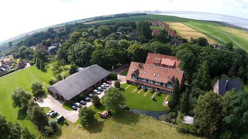 - une vue aérienne sur une grande maison avec une cour dans l'établissement Der Deichhof - Ferienwohnungen, à Wremen