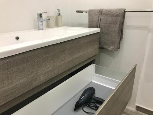 La salle de bains est pourvue d'un lavabo et d'un téléphone noir. dans l'établissement Luxueux appt Vieil Antibes Port Plage TOUT équipé pour 8, à Antibes