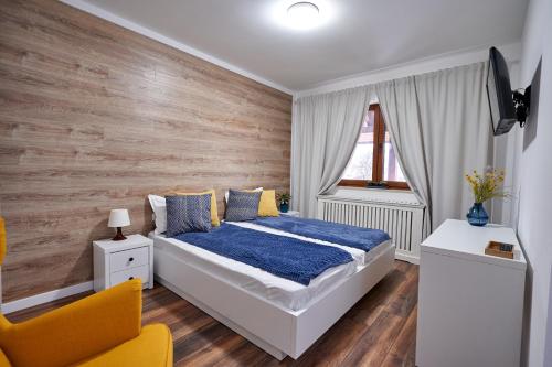 een slaapkamer met een bed met een houten muur bij La Antigua in Vişeu de Sus