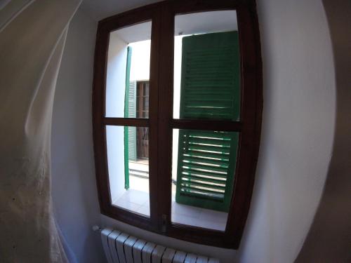 a window with green shutters on a wall at Casa Margarita in Sóller