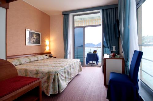 a hotel room with a bed and a large window at Hotel San Terenzo in Lerici