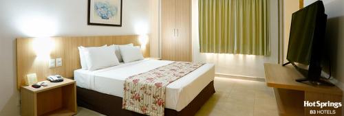 HotSprings ApartHotel في كالدس نوفاس: غرفة فندقية مع سرير وتلفزيون بشاشة مسطحة