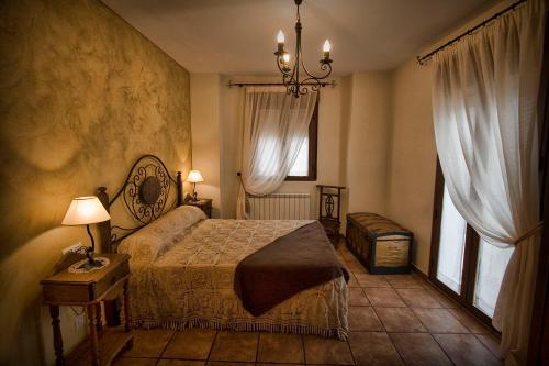 Casa Rural el Herrero de Pollos في Pollos: غرفة نوم بسرير ونوافذ