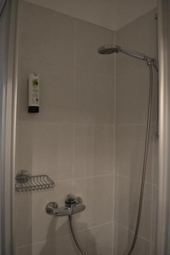 eine Dusche im Bad mit Duschvorhang in der Unterkunft Hotel-Café-Galerie in Garbsen