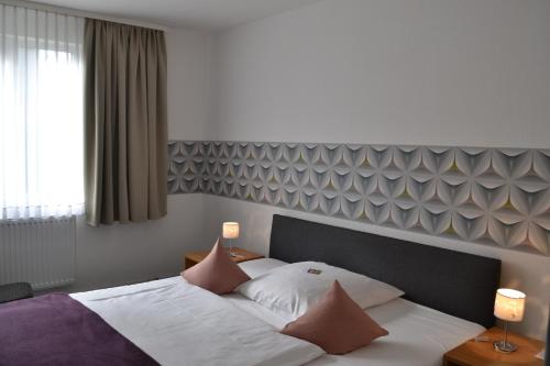 ein Schlafzimmer mit einem Bett mit Kissen darauf in der Unterkunft Hotel-Café-Galerie in Garbsen